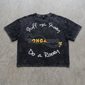 A black acid-wash graphic t-shirt laid flat on a textured gray concrete background. The shirt features white handwritten-style text reading 'Stuff Ya Shoes' and 'Do a Roar' with a central yellow and white 'BONGAROO' logo.