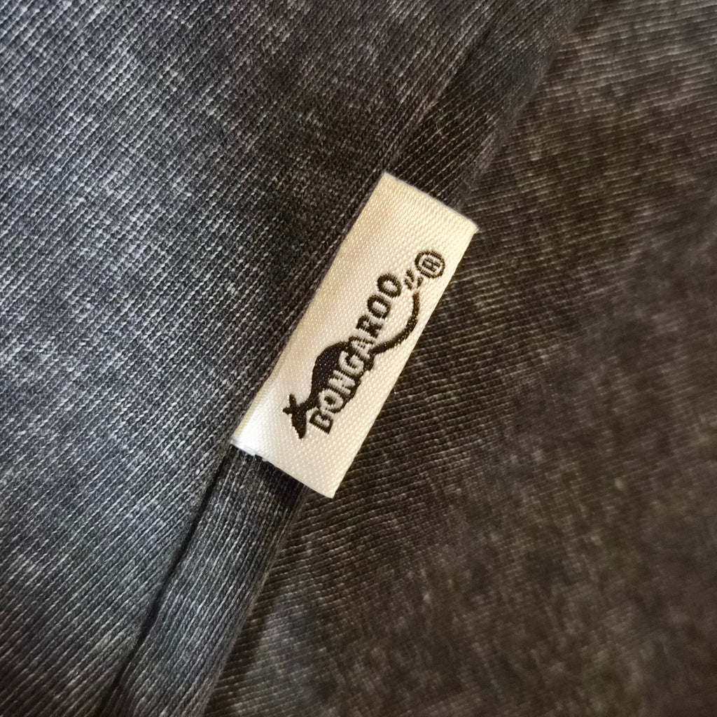 Close-up of a dark charcoal gray textured fabric with a small white sewn-in label reading PoloCLOO.